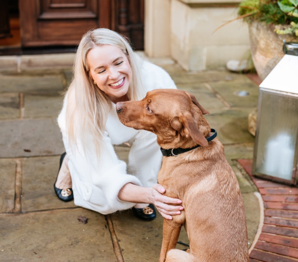 Woman stroking a golden dog affectionately