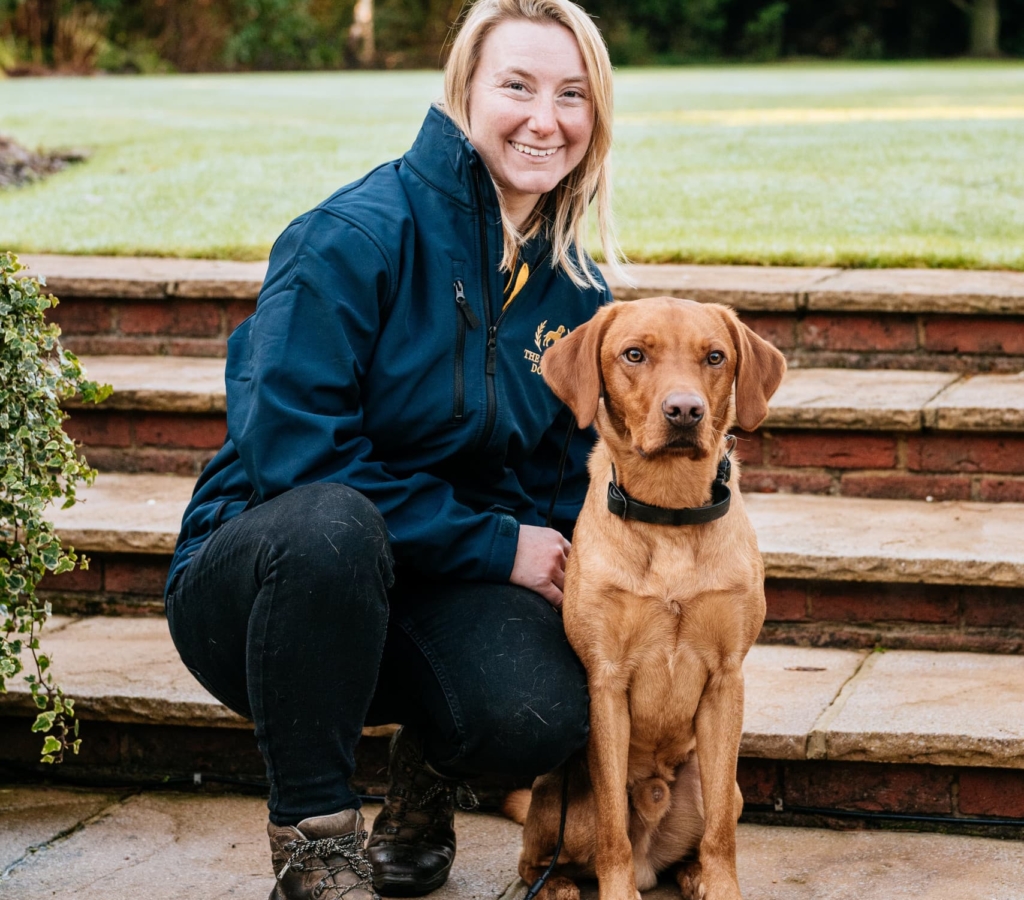 Woman sitting with trained dog on steps