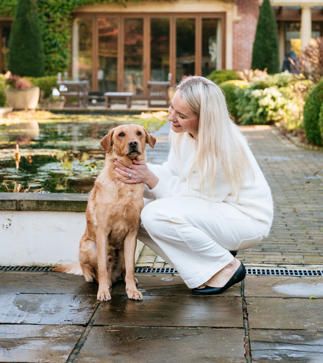 Woman with trained dog beside water outdoors
